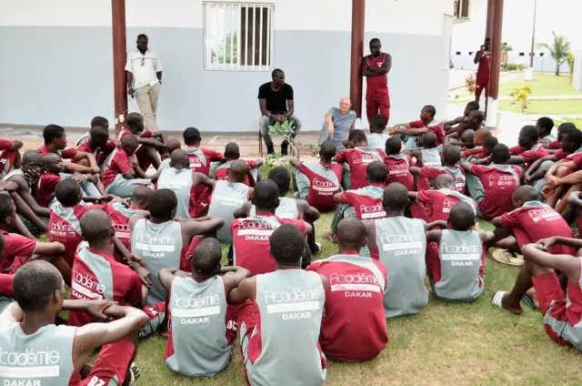 Jeunes footballeurs de Génération Foot écoutent les consignes de leurs entraîneurs