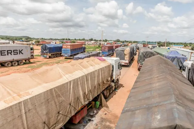 Longues files de camions bloqués à la frontière entre le Bénin et le Niger, illustrant les conséquences de la crise