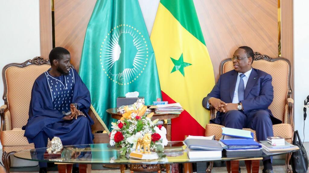 Rencontre entre le président sénégalais Macky Sall et son successeur Bassirou Diomaye Faye, symbole d'une transition politique sous haute tension.