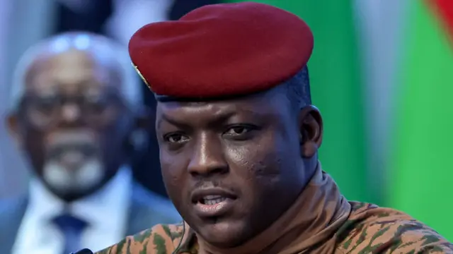 Portrait du capitaine Ibrahim Traoré, vêtu d'une tenue militaire beige et d'un béret rouge